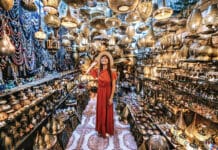 94 % des Français, rapportent un souvenir de vacances ! Jeune voyageuse visitant une boutique d’artisanat de souvenirs en cuivre à Marrakech, Maroc
