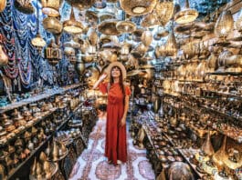 Jeune voyageuse visitant une boutique d’artisanat de souvenirs en cuivre à Marrakech, Maroc