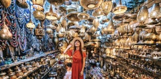 Jeune voyageuse visitant une boutique d’artisanat de souvenirs en cuivre à Marrakech, Maroc