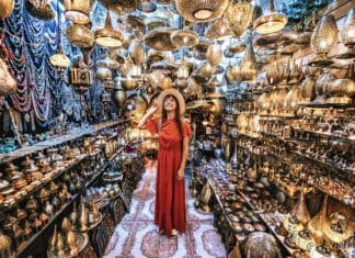 94 % des Français, rapportent un souvenir de vacances ! Jeune voyageuse visitant une boutique d’artisanat de souvenirs en cuivre à Marrakech, Maroc