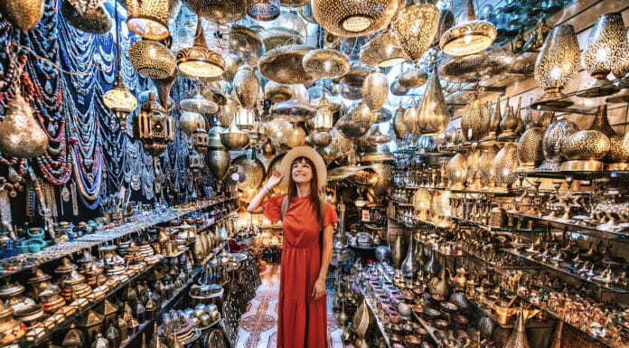 94 % des Français, rapportent un souvenir de vacances ! Jeune voyageuse visitant une boutique d’artisanat de souvenirs en cuivre à Marrakech, Maroc