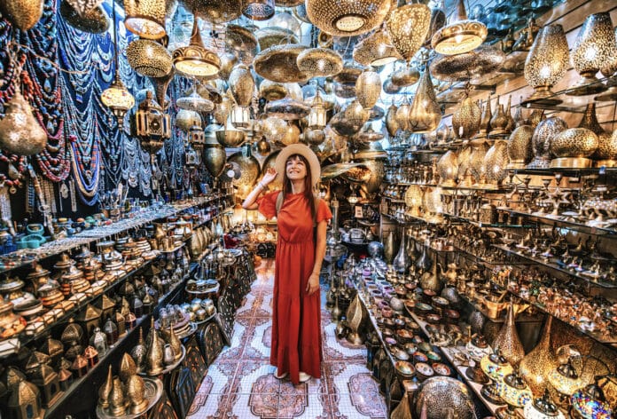 Young traveling woman visiting a copper souvenir handicraft shop in Marrakesh, Morocco - Travel lifestyle concept Jeune voyageuse visitant une boutique d’artisanat de souvenirs en cuivre à Marrakech, Maroc